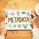 Word Metadata in education shown written on a notebook with a person holding a pen