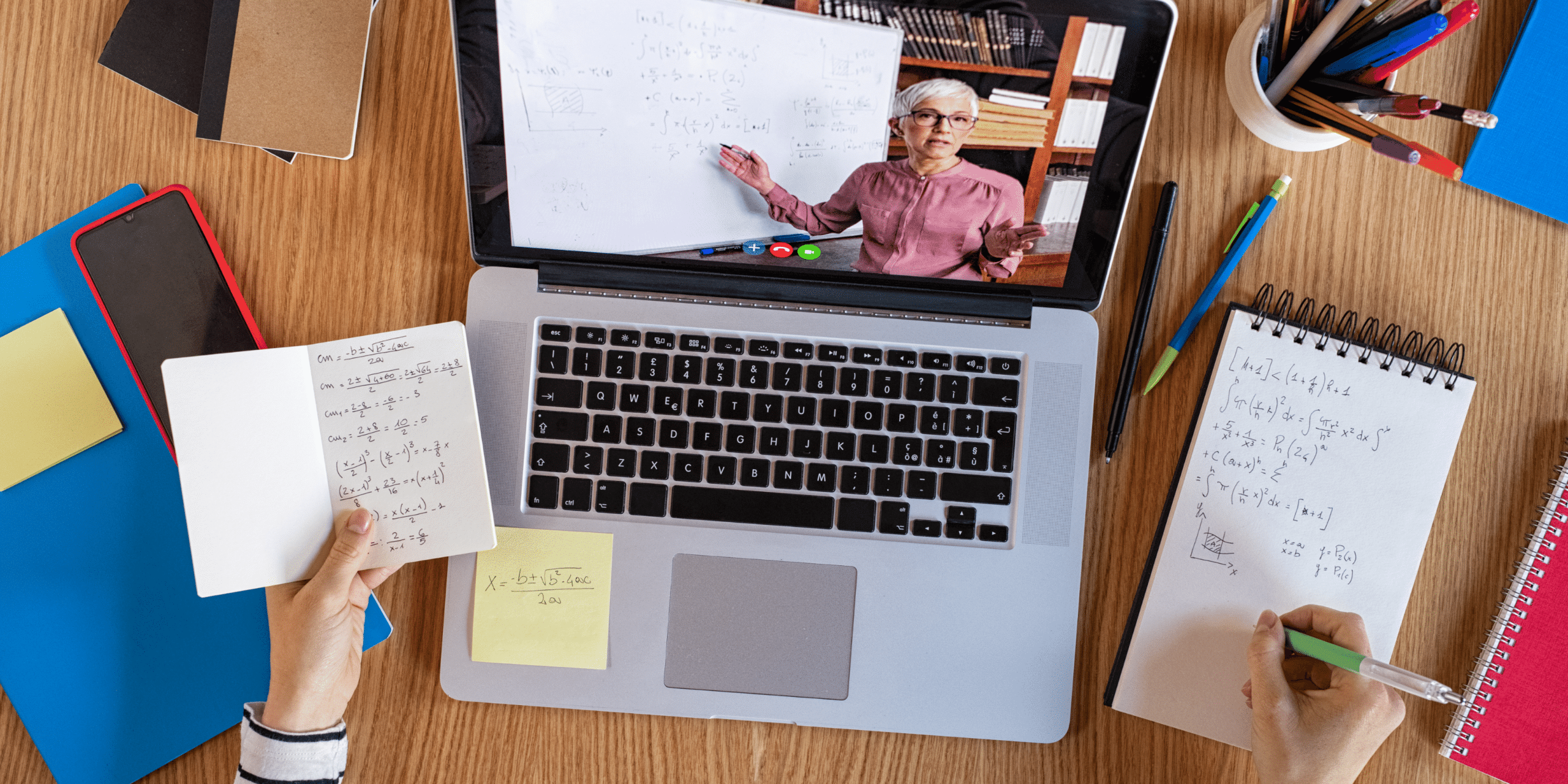 Person learning mathematics online, taking notes.
