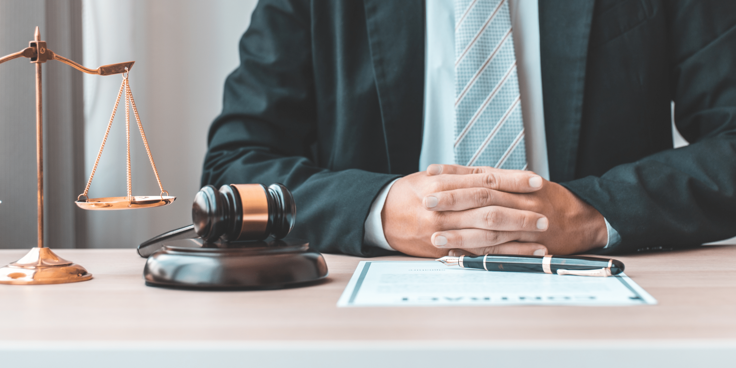 Lawyer with a scale, gavel, and documents sitting at a table